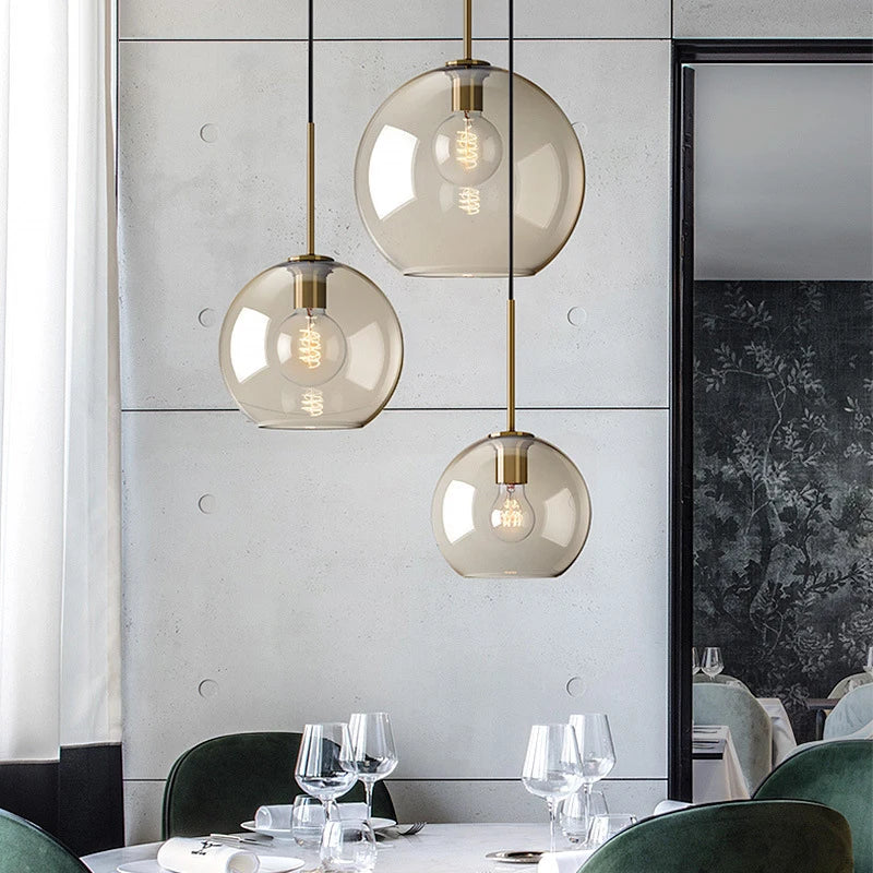 Nordic glass pendant light suspended above a kitchen island in a modern Scandinavian-inspired home.
