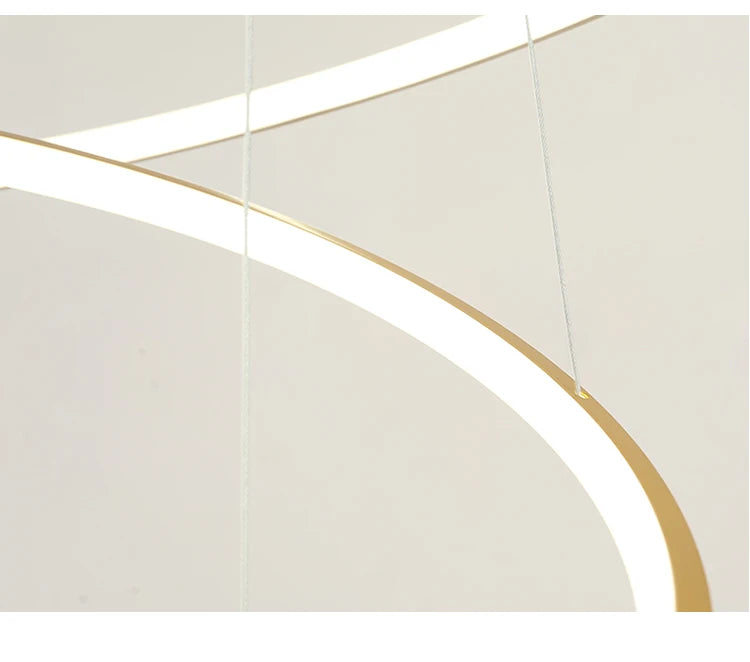 Modern LED ring chandelier suspended above a dining table in a luxury contemporary home.