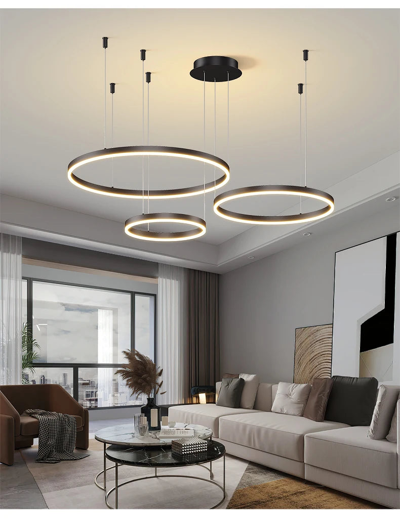 Modern LED circular ring chandelier installed above a dining table in a contemporary luxury home.