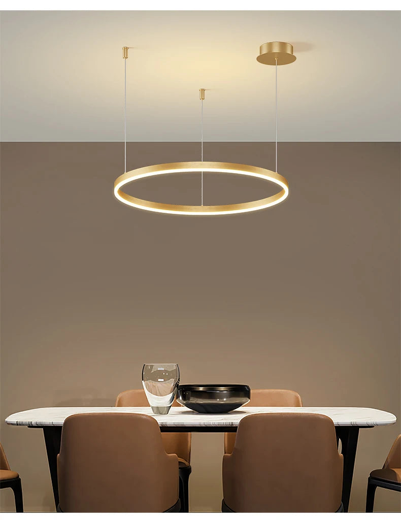 Modern LED circular ring chandelier installed above a dining table in a contemporary luxury home.