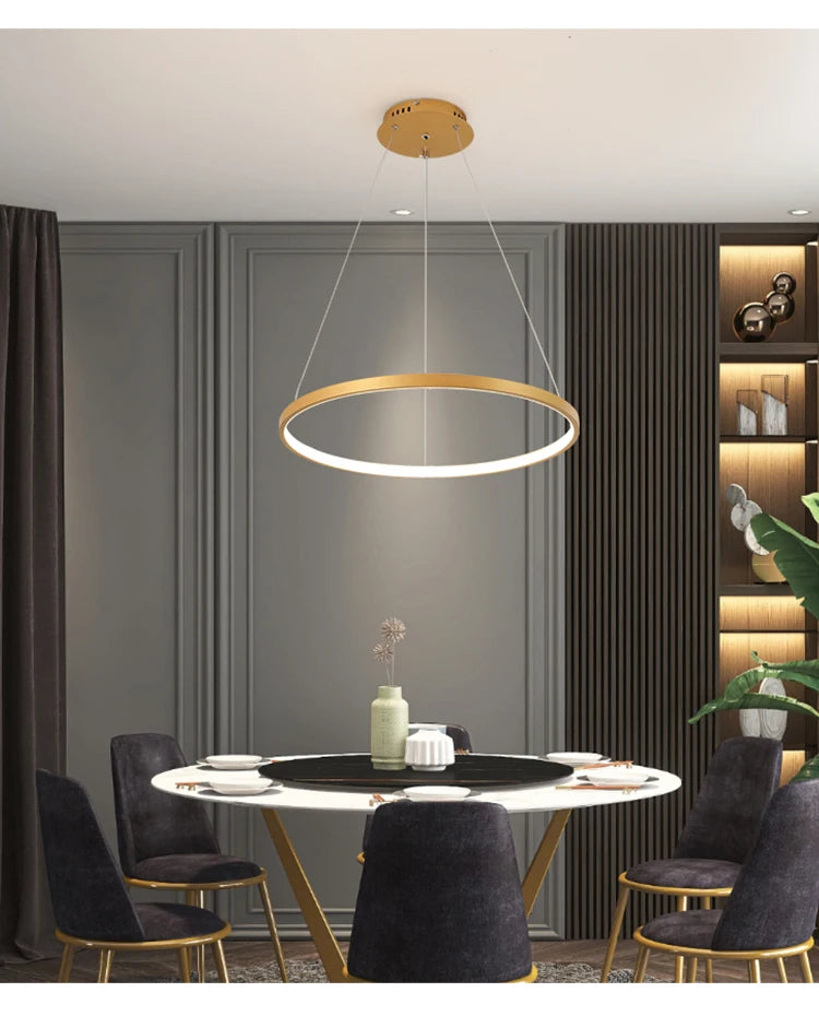 Modern LED ring chandelier suspended above a dining table in a luxury contemporary home.