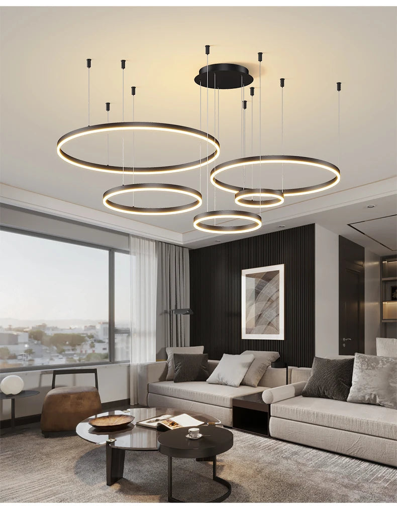 Modern LED circular ring chandelier installed above a dining table in a contemporary luxury home.