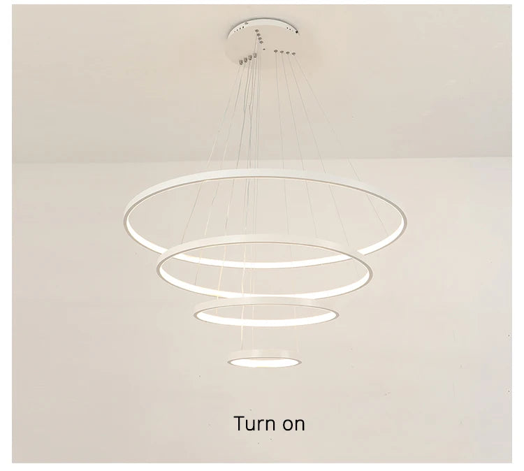 Modern LED ring chandelier suspended above a dining table in a luxury contemporary home.