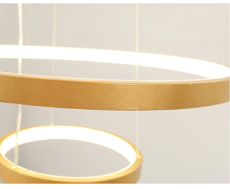 Modern LED ring chandelier suspended above a dining table in a luxury contemporary home.