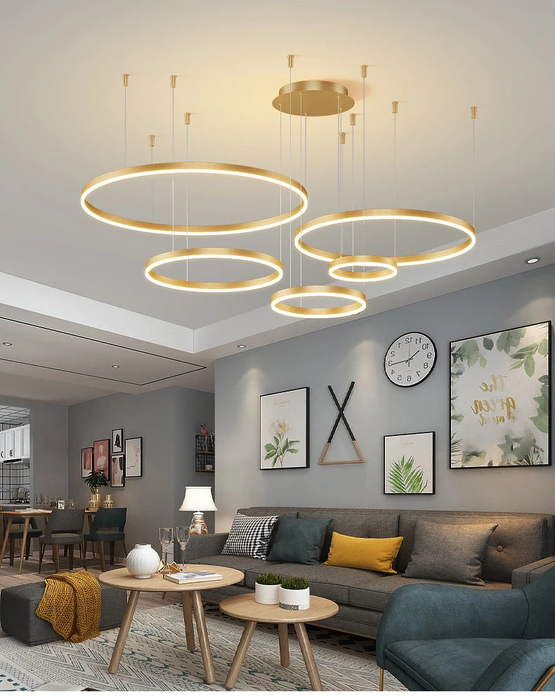 Modern LED circular ring chandelier installed above a dining table in a contemporary luxury home.