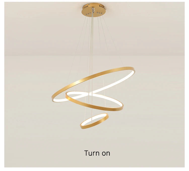 Modern LED ring chandelier suspended above a dining table in a luxury contemporary home.