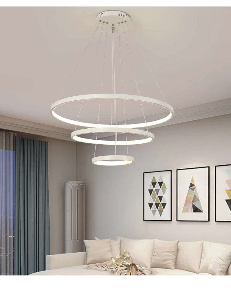 Modern LED ring chandelier suspended above a dining table in a luxury contemporary home.