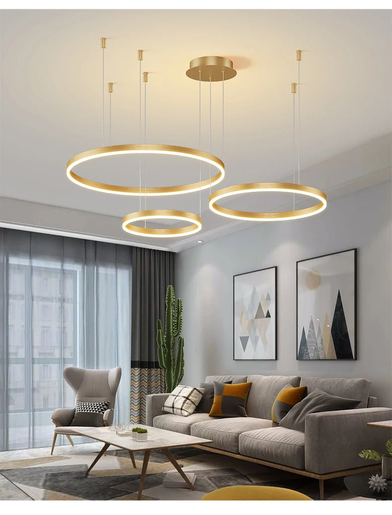 Modern LED circular ring chandelier installed above a dining table in a contemporary luxury home.