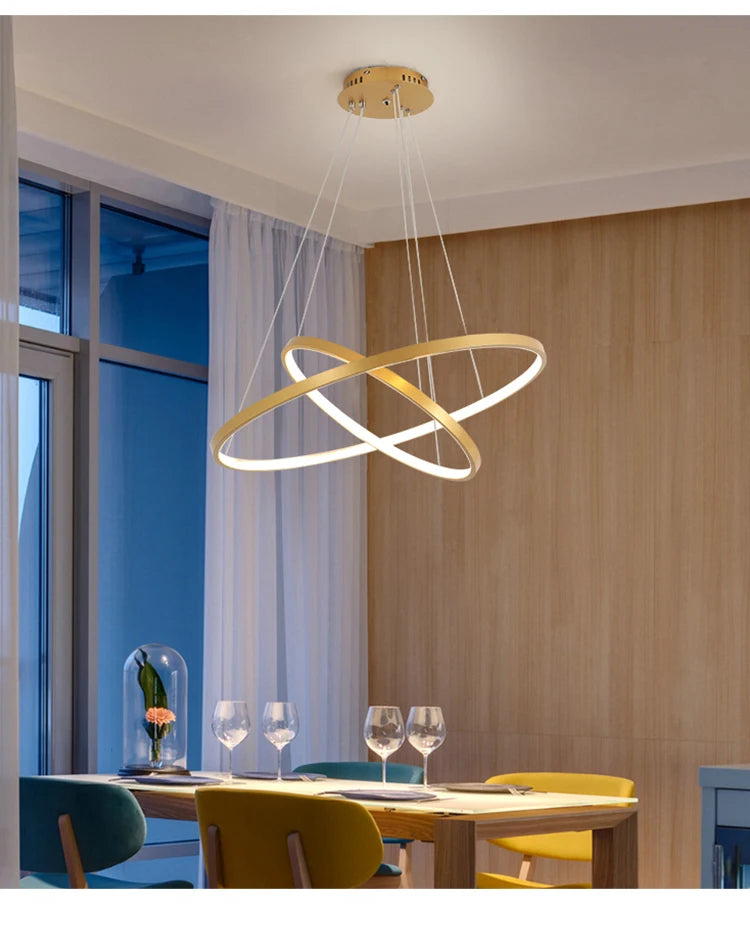Modern LED ring chandelier suspended above a dining table in a luxury contemporary home.