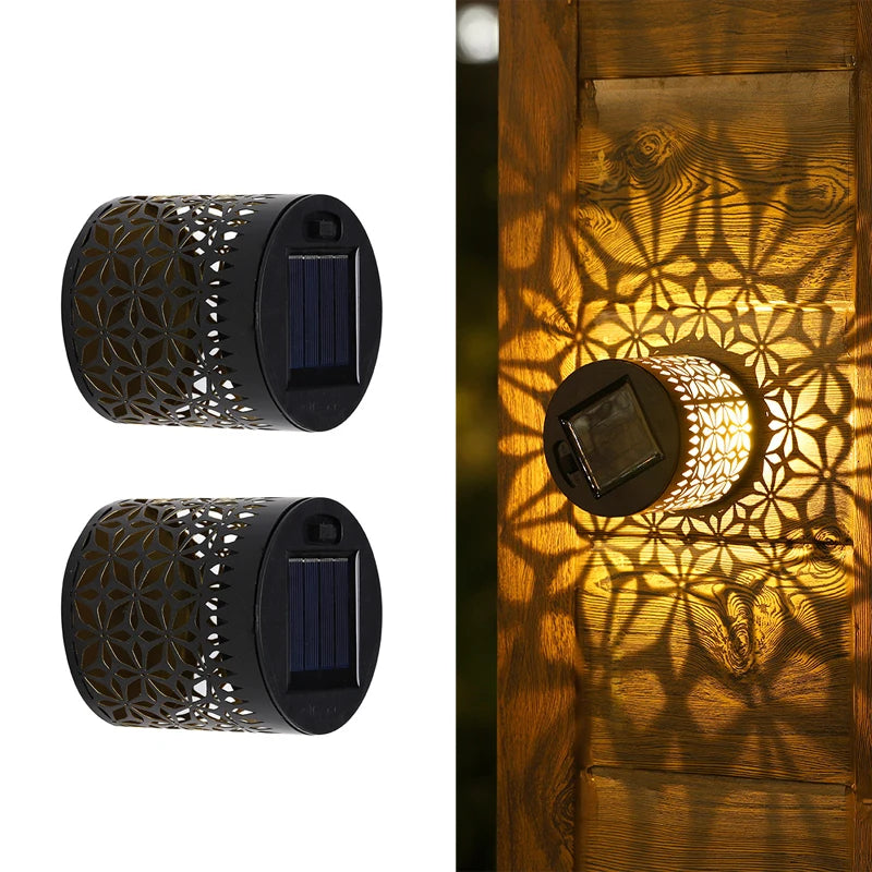 Modern waterproof solar projection LED wall light casting a decorative light pattern on an outdoor garden wall.
