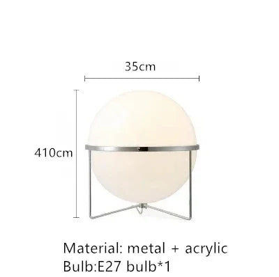 Luxury chrome globe floor lamp with a white acrylic globe beside a modern sofa in a contemporary living room.