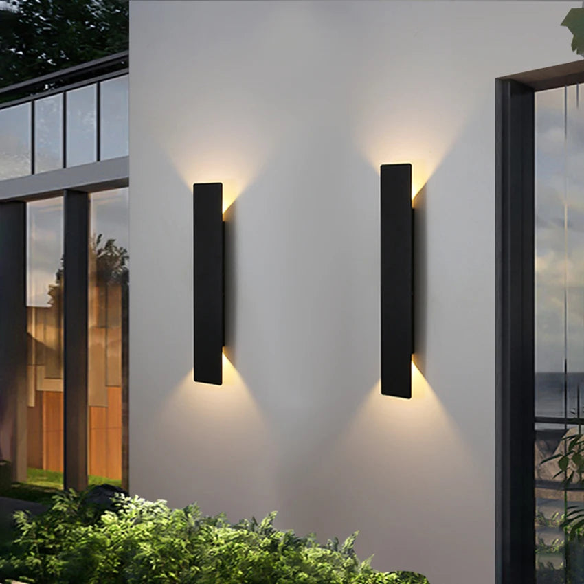 Modern black aluminum IP65 waterproof LED wall light mounted on an exterior wall with an up-and-down lighting effect.