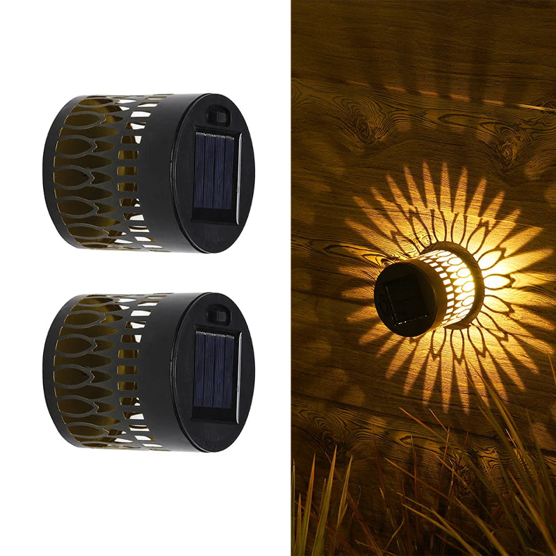Modern waterproof solar projection LED wall light casting a decorative light pattern on an outdoor garden wall.