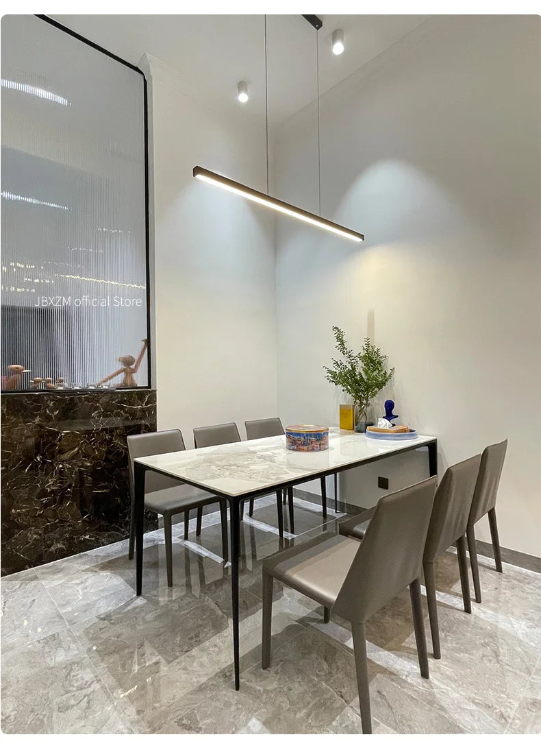 Modern linear LED pendant light suspended above a dining table in a contemporary dining room.
