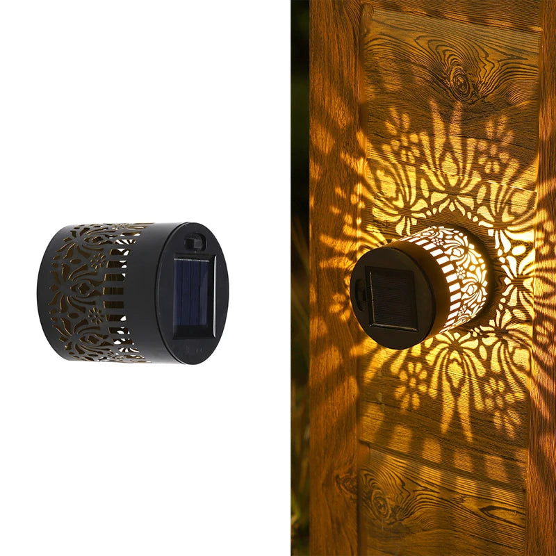 Modern waterproof solar projection LED wall light casting a decorative light pattern on an outdoor garden wall.