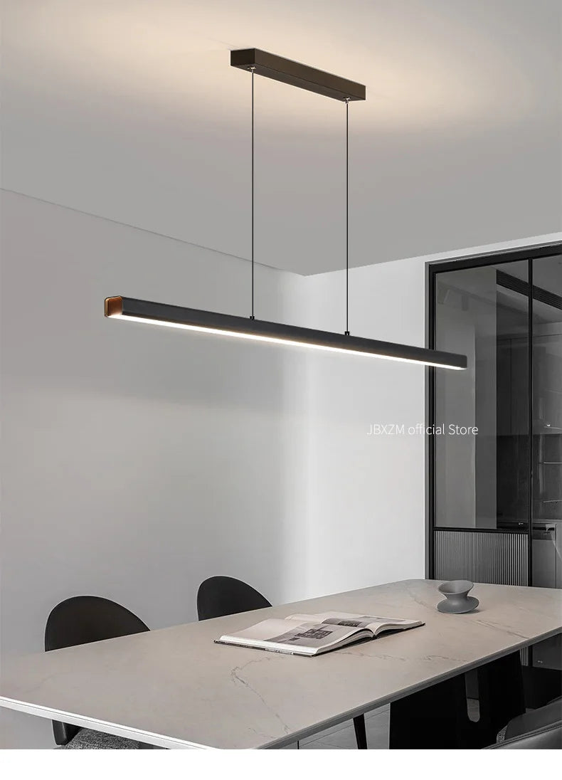 Modern linear LED pendant light suspended above a dining table in a contemporary dining room.