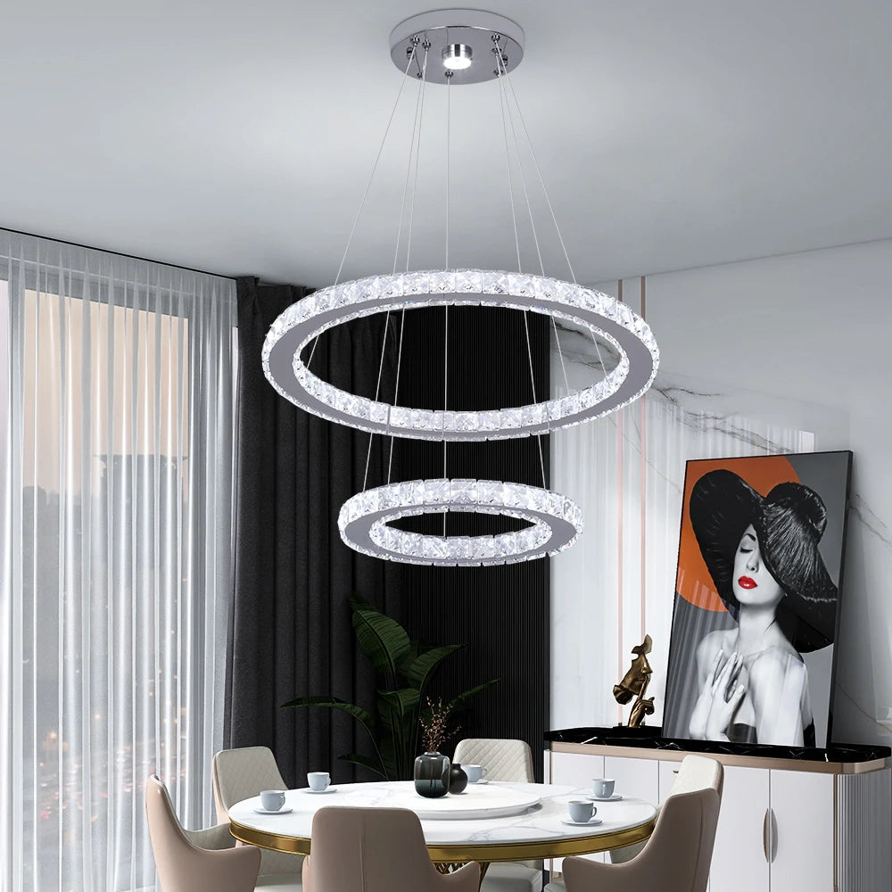 Luxury crystal ring LED chandelier suspended above a modern dining table in an elegant contemporary home.