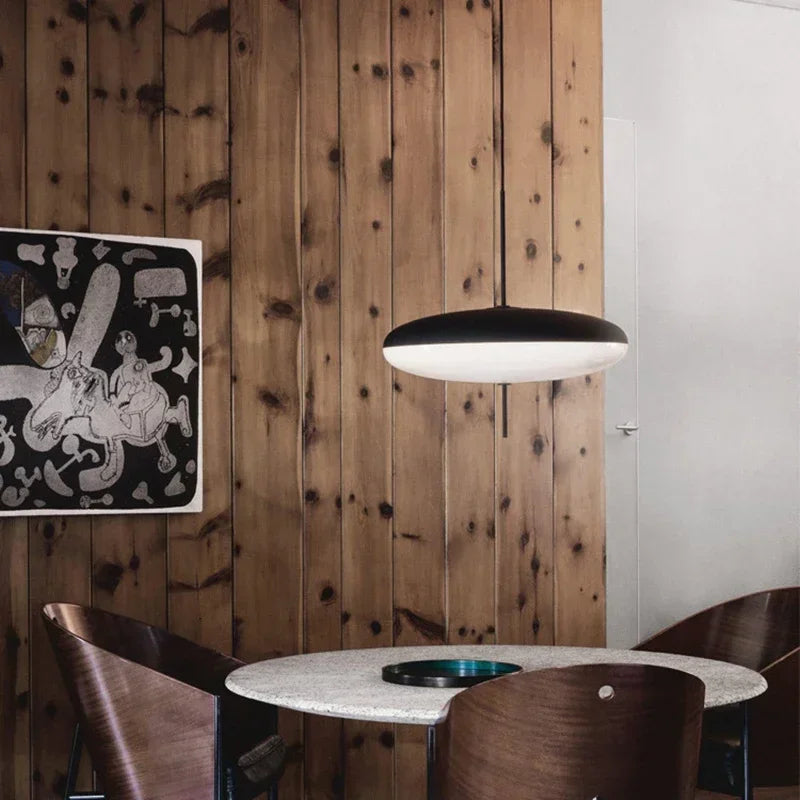 Nordic flying saucer LED pendant light hanging in a modern living room with minimalist décor.