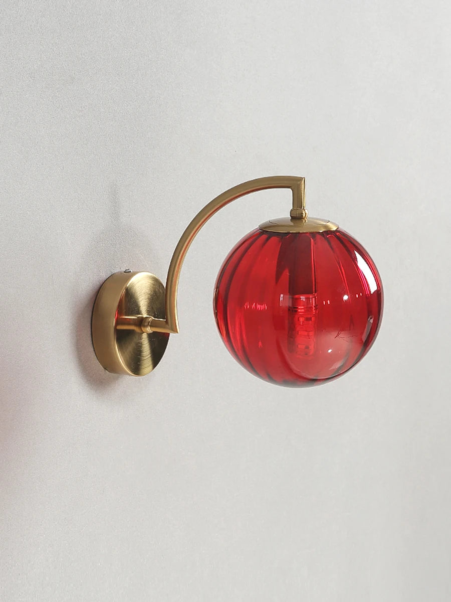 Modern Nordic glass LED wall sconce mounted beside a bed in a contemporary bedroom with warm ambient lighting.