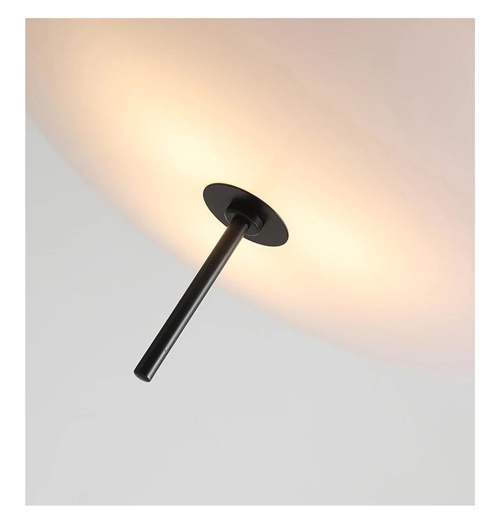 Nordic flying saucer LED pendant light hanging in a modern living room with minimalist décor.