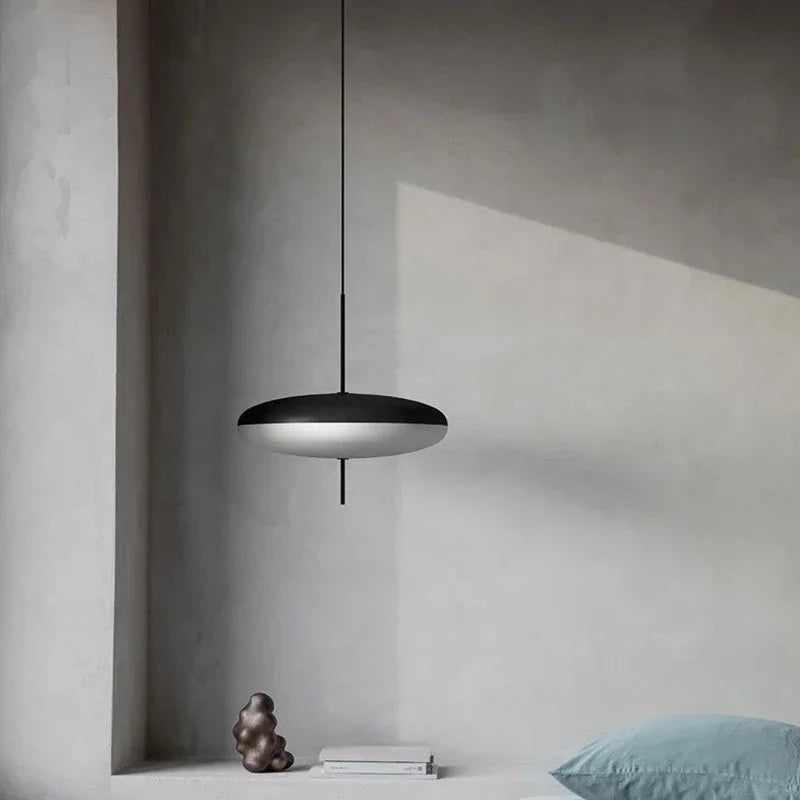 Nordic flying saucer LED pendant light hanging in a modern living room with minimalist décor.