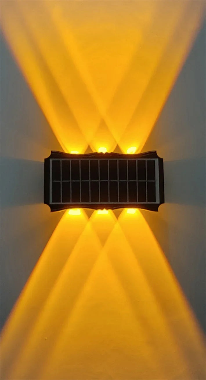 Modern waterproof solar LED wall light installed on an exterior wall illuminating a garden pathway.