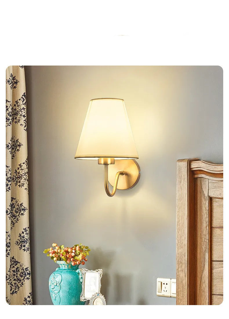 Modern fabric wall sconce installed beside a bed in a contemporary bedroom with warm ambient lighting.
