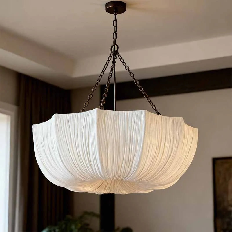 Japanese fabric pendant light with iron chain hanging above a modern dining table in a Japandi-style home.
