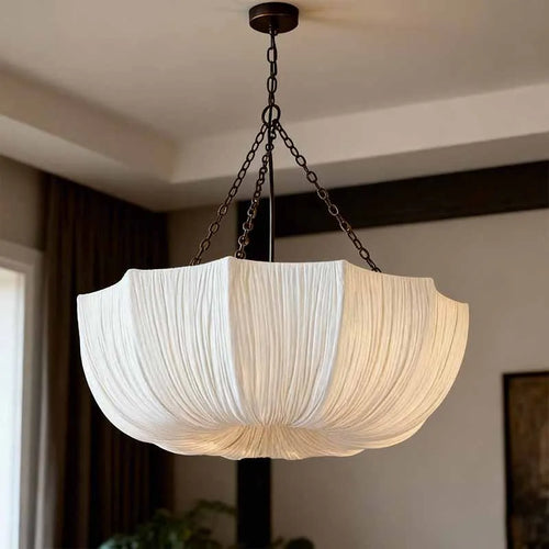 Japanese fabric pendant light with iron chain hanging above a modern dining table in a Japandi-style home.