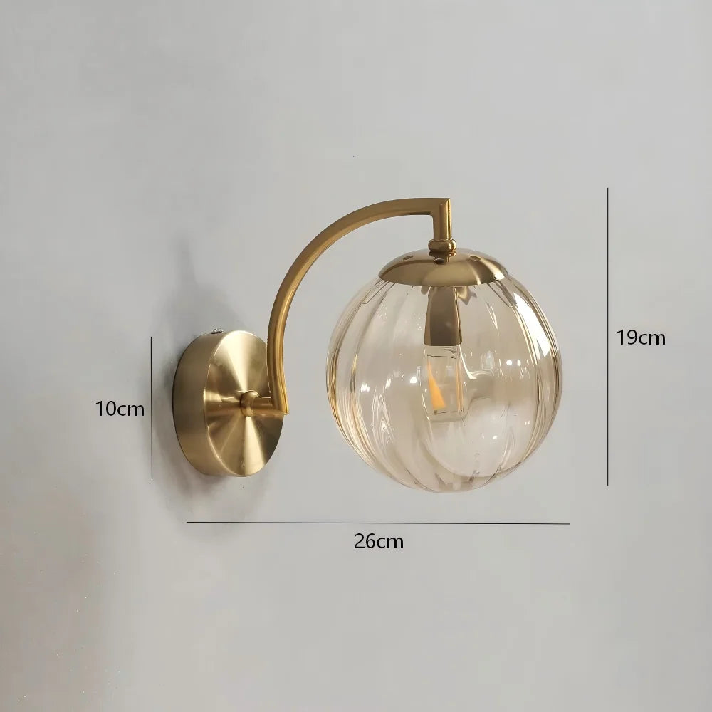 Modern Nordic glass LED wall sconce mounted beside a bed in a contemporary bedroom with warm ambient lighting.
