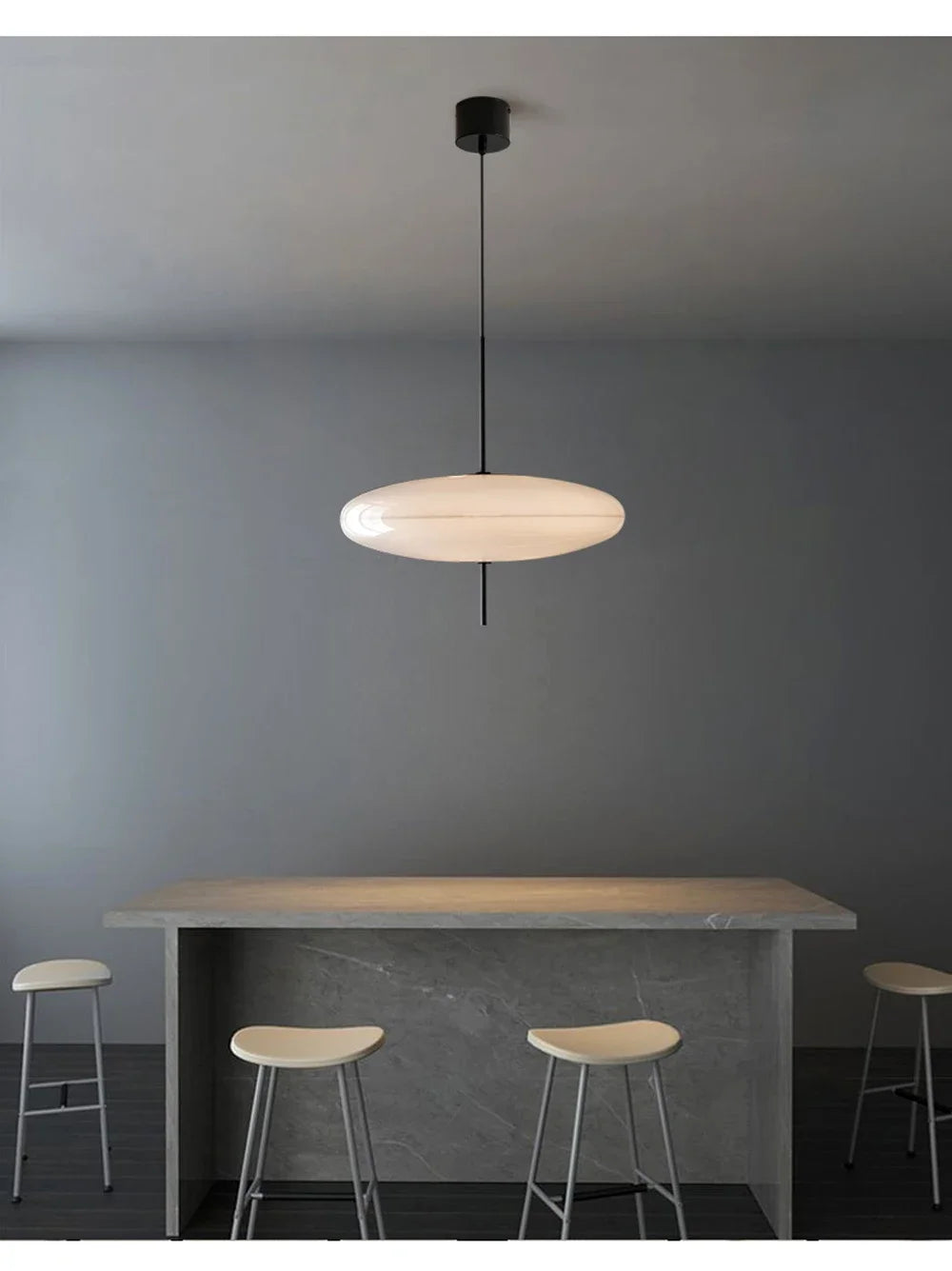 Nordic flying saucer LED pendant light hanging in a modern living room with minimalist décor.