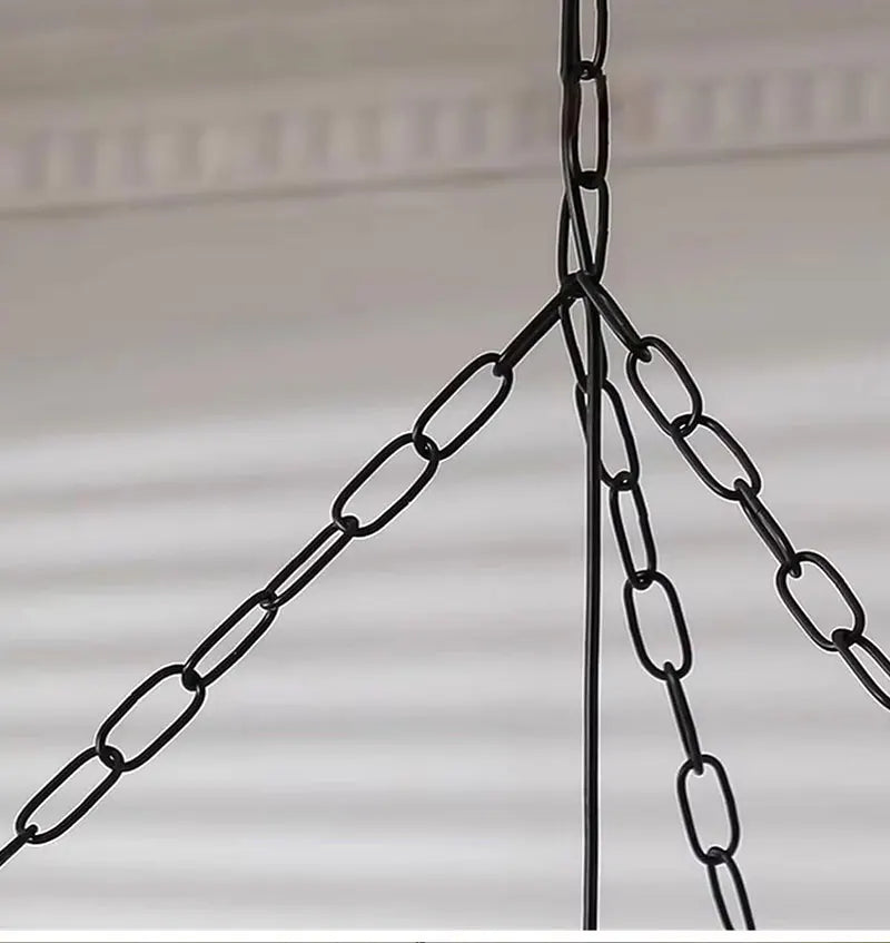 Japanese fabric pendant light with iron chain hanging above a modern dining table in a Japandi-style home.