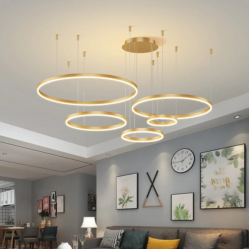 Modern LED circular ring chandelier installed above a dining table in a contemporary luxury home.