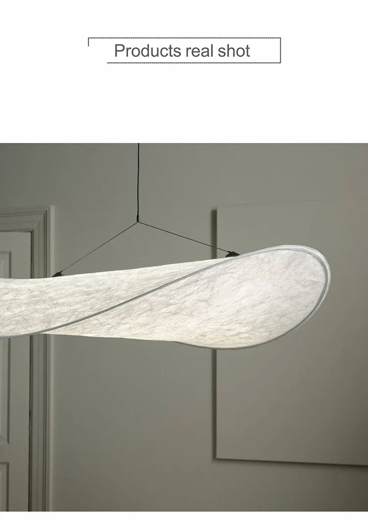 Nordic modern LED pendant light hanging above a dining table in a contemporary living room.