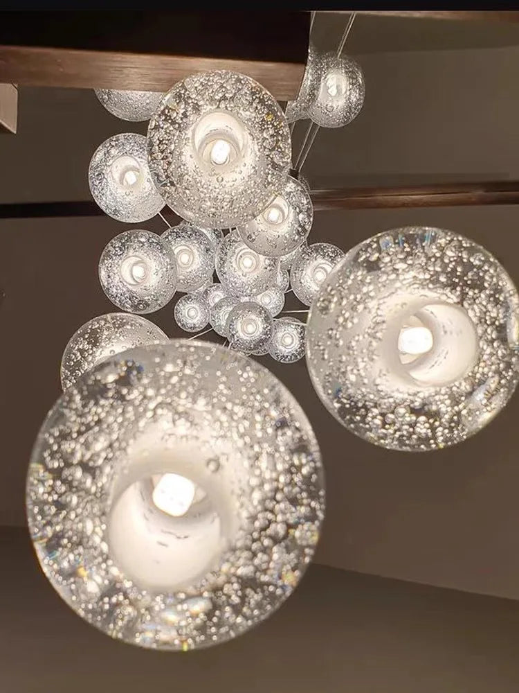 Modern spiral crystal LED chandelier cascading down a luxury staircase in a contemporary home.