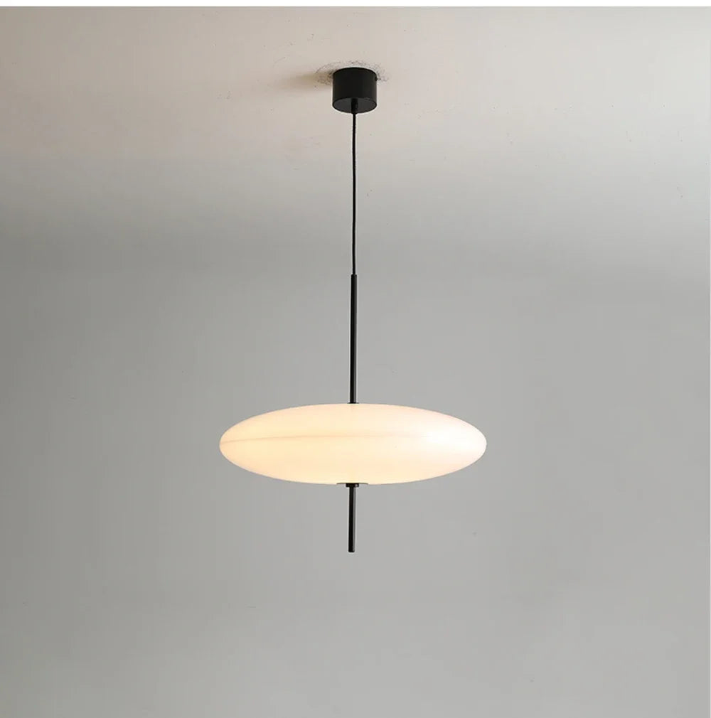 Nordic flying saucer LED pendant light hanging in a modern living room with minimalist décor.