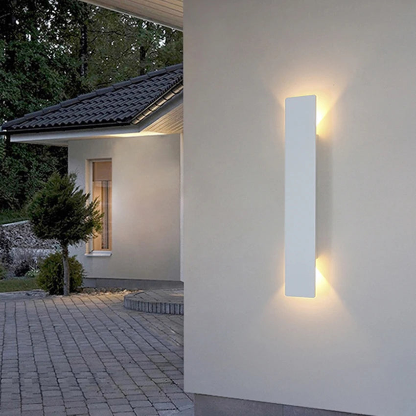 Modern black aluminum IP65 waterproof LED wall light mounted on an exterior wall with an up-and-down lighting effect.