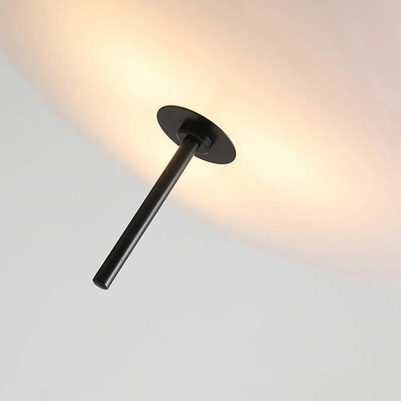 Nordic flying saucer LED pendant light hanging in a modern living room with minimalist décor.
