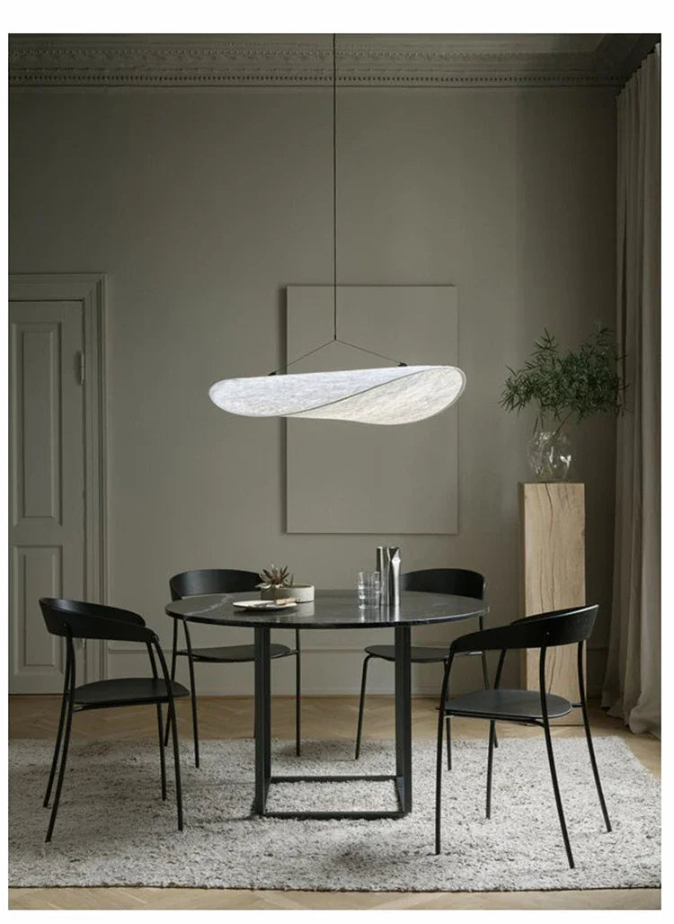 Nordic modern LED pendant light hanging above a dining table in a contemporary living room.