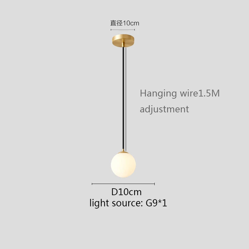 Modern glass globe pendant light with gold finish hanging above a contemporary dining table.