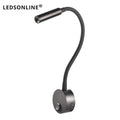Modern LED wall reading light mounted beside a bed, providing focused lighting for reading.