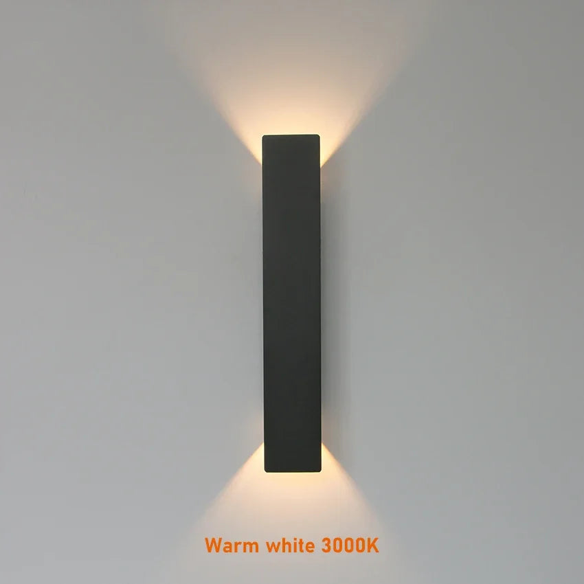 Modern black aluminum IP65 waterproof LED wall light mounted on an exterior wall with an up-and-down lighting effect.