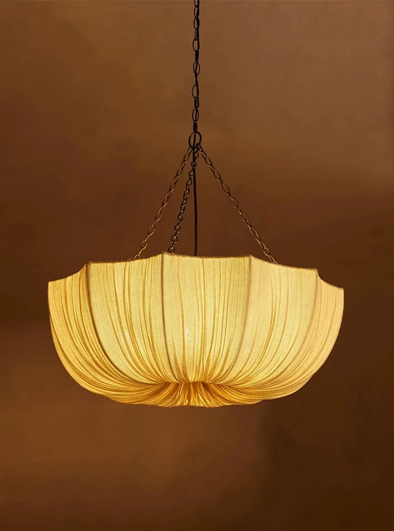 Japanese fabric pendant light with iron chain hanging above a modern dining table in a Japandi-style home.