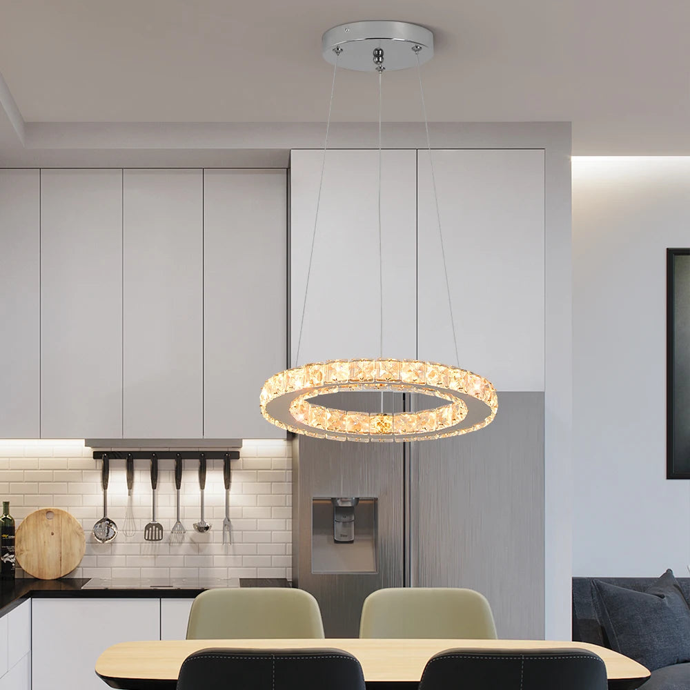 Luxury crystal ring LED chandelier suspended above a modern dining table in an elegant contemporary home.