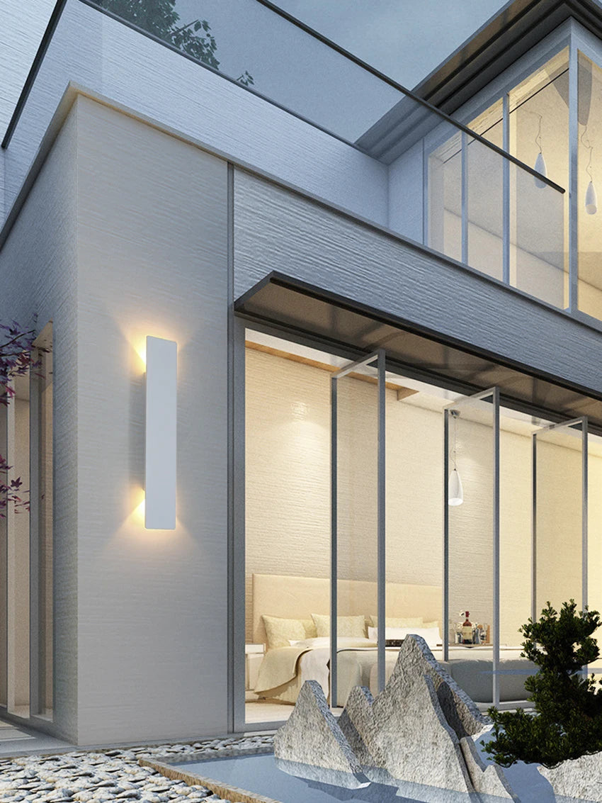 Modern black aluminum IP65 waterproof LED wall light mounted on an exterior wall with an up-and-down lighting effect.