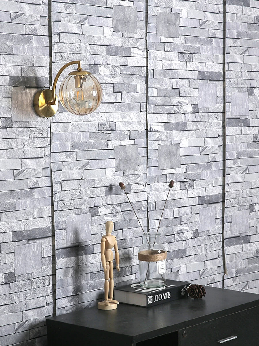 Modern Nordic glass LED wall sconce mounted beside a bed in a contemporary bedroom with warm ambient lighting.
