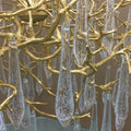 Luxury gold branch crystal chandelier hanging in a modern living room with elegant contemporary décor.