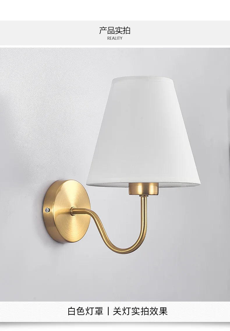 Modern fabric wall sconce installed beside a bed in a contemporary bedroom with warm ambient lighting.