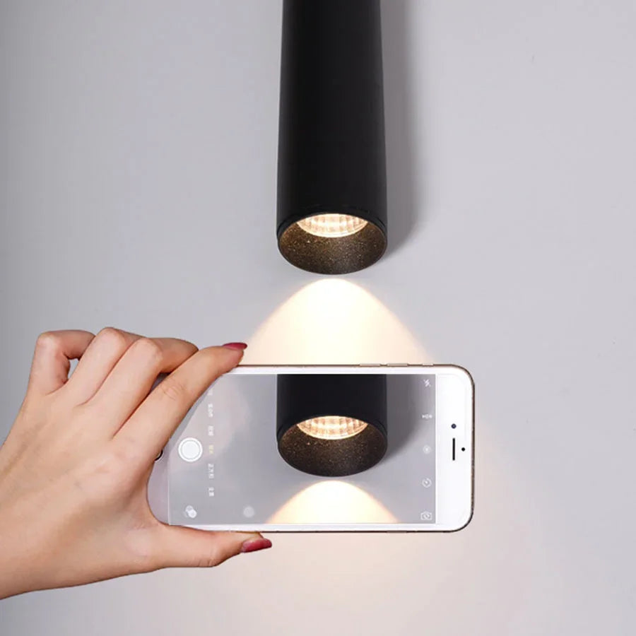 Modern cone LED pendant light hanging above a kitchen island in a contemporary home.