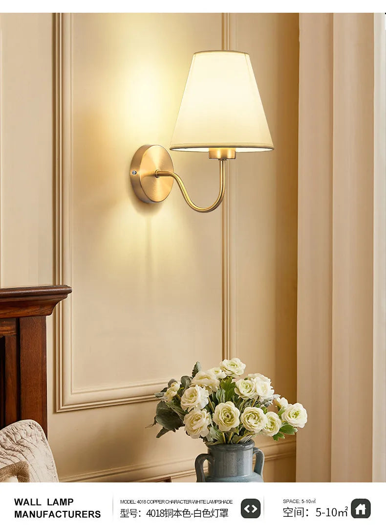 Modern fabric wall sconce installed beside a bed in a contemporary bedroom with warm ambient lighting.